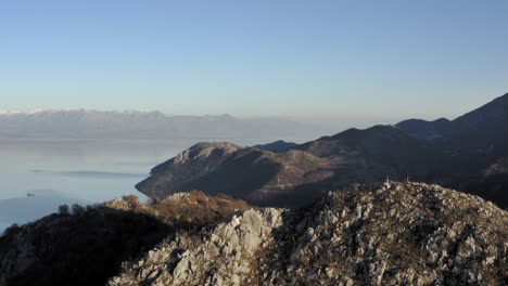 AERIAL---Clear-blue-sky-in-mountains-around-Lake-Skadar,-Montenegro,-lowering