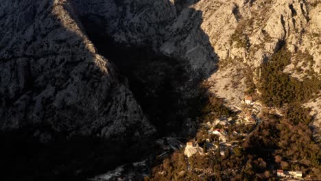 AERIAL---Valley-around-the-ancient-city-of-Kotor,-Montenegro,-rising-tilt-down