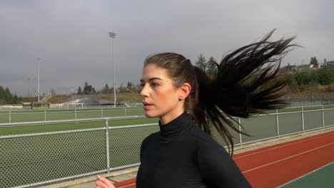 Young-Beautiful-Sporty-Woman-Running-on-the-Track,-Slow-Motion-Follow