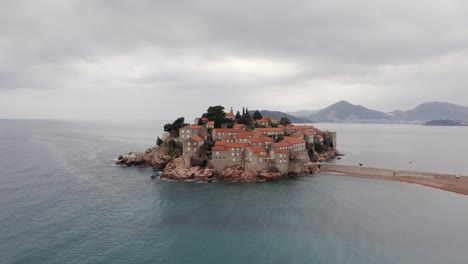AERIAL---Sveti-Stefan-island-luxury-resort,-tombolo,-on-the-Adriatic-Sea,-Montenegro