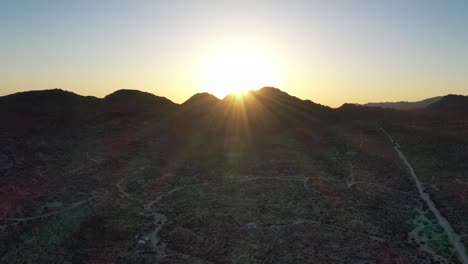 Heller-Goldener-Sonnenuntergang-über-Dem-Berg-Mit-Wüstenlandschaft-Im-Vordergrund