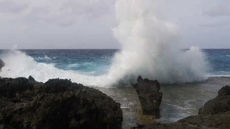 Eine-Meereswelle-Kracht-Gegen-Felsen-Entlang-Der-Küste-Und-Spritzt-Wasser-Hoch-In-Den-Himmel-Und-Auf-Das-Kameraobjektiv---Intensive-Zeitlupen-Action