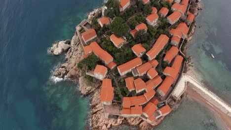 AERIAL---Sveti-Stefan-island-luxury-resort-and-tombolo,-Montenegro,-top-down-rising