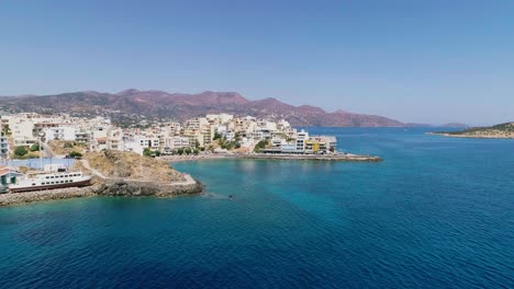 Drone-shot-over-the-marina,-seaside-boulevard,-beaches,-summer-in-Agios-Nikolaos-Crete-Greece