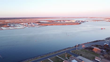 Aerial-drone-shot,-flying-over-crystal-clear-water-towards-a-marina-in-Cape-May-New-Jersey,-Cape-May-County