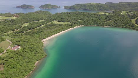 Aerial-of-turquoise-sea-and-dense-green-rainforest-irregular-coast-in-Nacascolo-beach,-Papagayo-Peninsula,-Costa-Rica