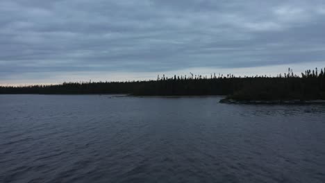 Drone-flying-over-a-lake-on-a-cloudy-evening