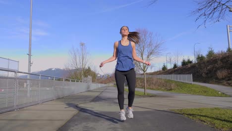 Fit-woman-skipping-outdoors-Wide-slow-motion-shot