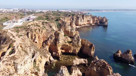 Ponta-Da-Piedade,-Lagos,-Algarve,-Portugal---Luftdrohnenansicht-Der-Küste-Mit-Felsklippen,-Verstecktem-Strand-Und-Klarem-Meer
