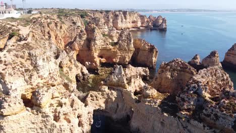Ponta-Da-Piedade,-Lagos,-Algarve---Aerial-Drone-View-of-the-Caves-and-Coastline-with-Rocky-Cliffs,-Hidden-Beach-and-Clear-Sea