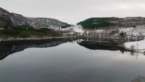 Toma-Aérea-Cinematográfica-Volando-Sobre-Un-Lago-Y-Una-Montaña-En-Noruega
