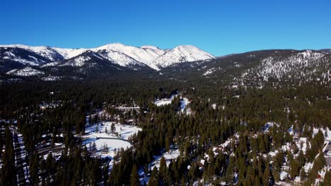 A-beautiful-aerial-drone-shot,-flying-over-the-woods-towards-the-glaciers-in-Lake-Tahoe,-Nevada-California