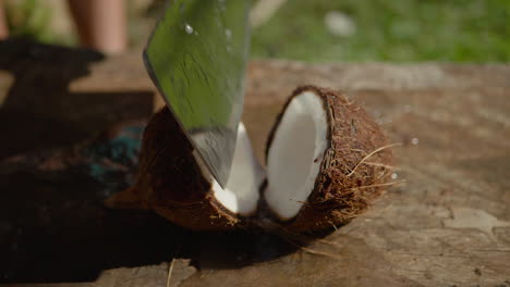 Fresh-coconut-cut-in-half-with-cleaver,-water-pours-out