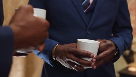 Erfolgreiche-Schwarze-Männer-In-Anzügen,-Die-Während-Eines-Geschäftstreffens-Kaffee-Trinken,-Wohlhabender-Afroamerikaner