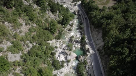 Video-Con-Un-Dron-Del-Descubrimiento-A-Vista-De-Pájaro-Del-Plano-Frontal-En-El-Río-Valbone,-Albania,-Adjunto-A-La-Carretera