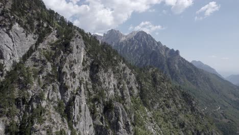 Frontal-drone-video-advancing-over-the-hills-of-the-Valbona-valley,-Albania,-fly-very-close-to-the-ground-appreciating-the-beauty-of-the-pines-and-trees-in-the-area
