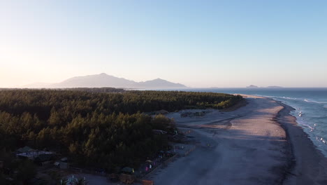 Drone-shot-of-seashore-with-trees-and-mountain