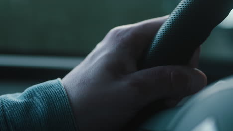 Close-Up-of-a-male-holding-the-stirring-wheel-of-a-car-driving-in-his-hands