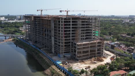 Aerial-Shot-Of-Cooum-River-Around-The-Construction-Buildings-Surrounded-By-Trees