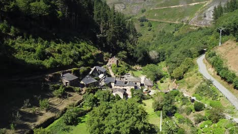Aerial-shot-of-drone-getting-very-close-to-a-little-town-on-the-valley-of-the-green-mountains-of-Asturias,-Spain