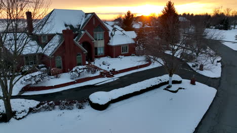Large-brick-mansion-home-in-winter-snow-sunset