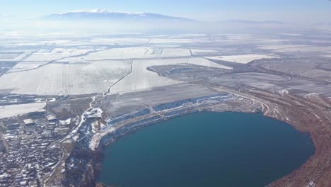 Drone-flight,-view-of-lake-next-to-the-city-during-winter-time,-Sofia,-Bulgaria