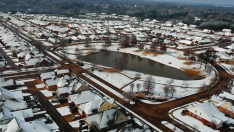 Snowy-rooftops-near-a-lake-from-drone-view