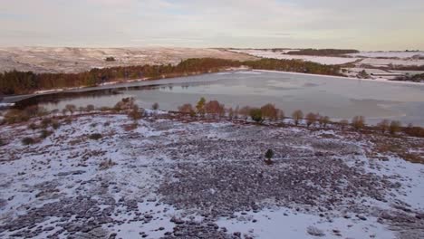 North-York-Moors-Lockwood-Beck-in-winter,-frozen-lake,-snow-on-ground,-aerial-drone-footage