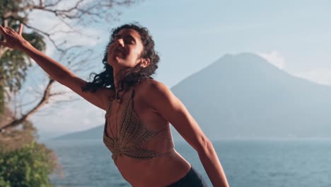 Attractive-Indian-female-dancing-with-majestic-lake-and-volcano-in-background