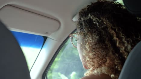 Cute-curly-girl-singing-in-the-front-seat