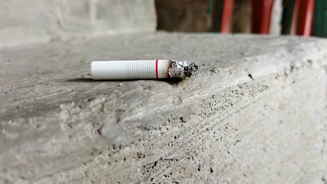 Close-up-of-a-cigarette-with-a-beautiful-puff-of-smoke-when-placed