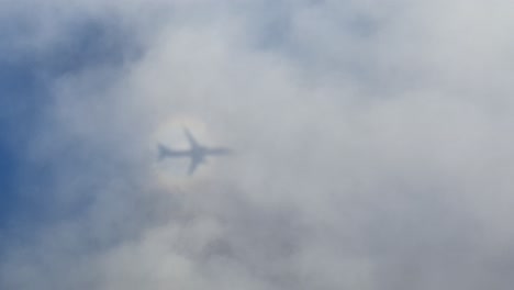 Flugzeug,-Das-Durch-Die-Wolken-Fliegt-Und-Einen-Schatten-Und-Sonnenblut-Oder-Einen-Kreisförmigen-Regenbogen-Wirft