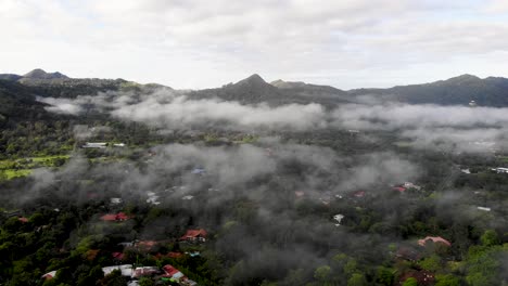 Approaching-clouds-cover-town-of-Valle-de-Anton-in-central-Panama-located-in-extinct-volcano-crater,-Aerial-wide-angle-close-in-shot