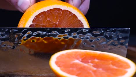 Hand-slicing-a-blood-orange-with-a-sharp-kitchen-knife