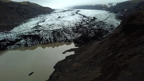 Aerial-landscape-view-of-Sólheimajökull-glacier,-Iceland,-melting-into-water,-in-summer