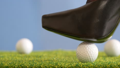 Frau-Rollt-Golfball-Mit-Ihren-Stöckelschuhen-Mit-Hohen-Absätzen-In-Position