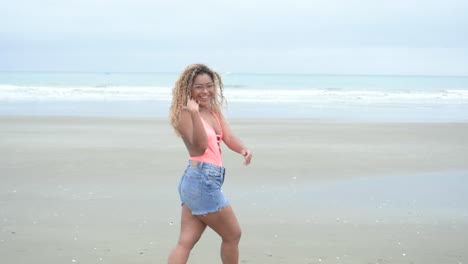 Curly-latina-walking-over-the-beach-and-waving-"come-here"