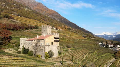 Aerial-Drone-Over-a-medieval-Castle-in-the-middle-of-the-Vineyards-in-Italy