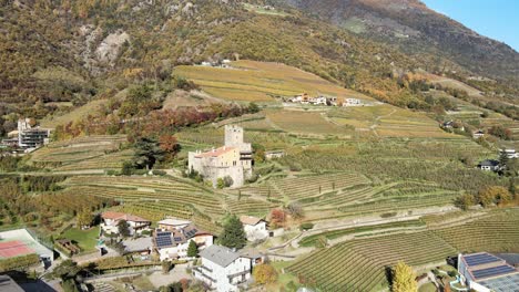 Aerial-Drone-Over-a-medieval-Castle-in-the-middle-of-the-Vineyards-in-Italy
