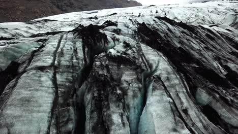 Vista-Aérea-Del-Paisaje-Sobre-La-Textura-Del-Glaciar-Sólheimajökull,-Islandia,-En-Verano