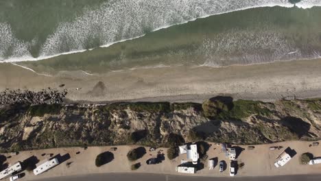A-stunning-static-aerial-drone-shot-of-waves-coming-in-to-the-beach,-Carlsbad-State-Beach---California