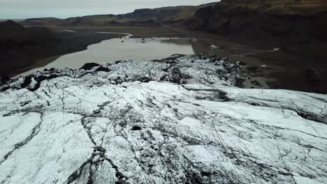 Aerial-landscape-view-over-Sólheimajökull-glacier,-Iceland,-melting-into-water,-in-summer