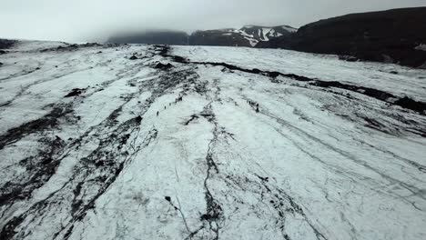 Vista-Aérea-Del-Paisaje-De-Personas-Caminando-En-El-Glaciar-Sólheimajökull,-Islandia,-Durante-El-Verano