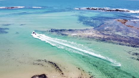 Drohnen-Luftaufnahme-Eines-Bootes,-Das-Durch-Eine-Türkisfarbene-Bucht-In-Australien-Fährt