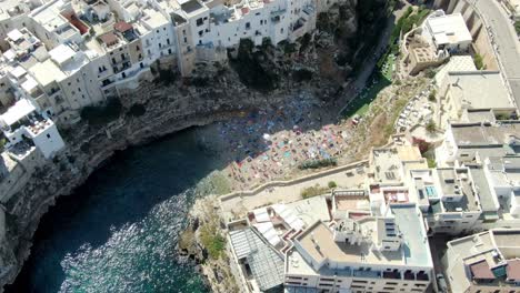 Drone-zooms-in-Polignano-a-Mare-beach-in-Italy-and-crystal-blue-water-of-Adriatic-sea-can-be-seen