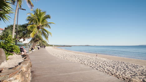 Noosa-Heads-Main-Beach-Tropical-Beachside-Boardwalk-With-Palm-Trees,-4K-Slow-Motion