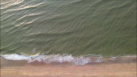 Top-down-aerial-view-of-sea-waves-washing-up-on-beach