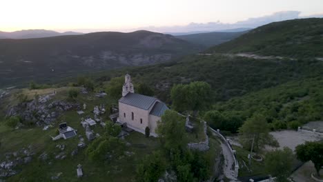 Pequeña-Iglesia-En-La-Cima-De-Una-Colina-Contra-Un-Hermoso-Paisaje-Verde,-Montenegro