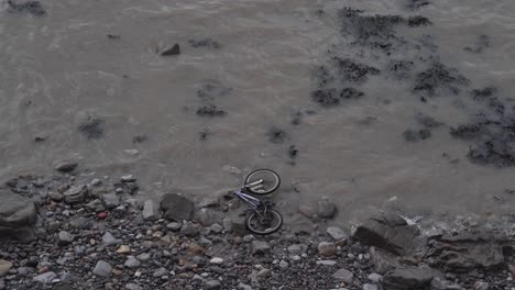 Bicycle-abandoned-in-the-beach,-waves-crushing-into-a-bike-that-was-trowed-into-the-sea
