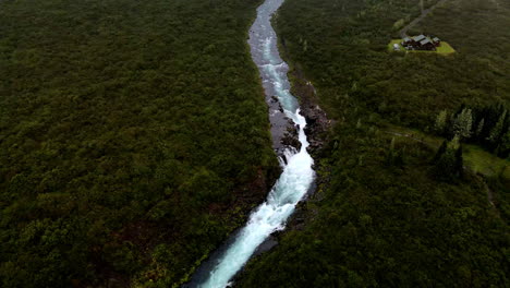 Fluss-Mit-Einem-Wasserfall,-Umgeben-Von-Bäumen-Und-Vegetation-In-Island